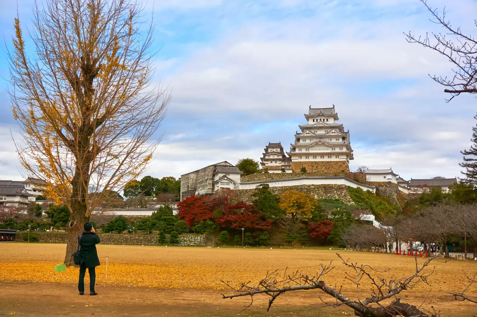 man stands and takes a photo of himeji castle in cloudy day man stands and takes a photo of himeji castle in cloudy day