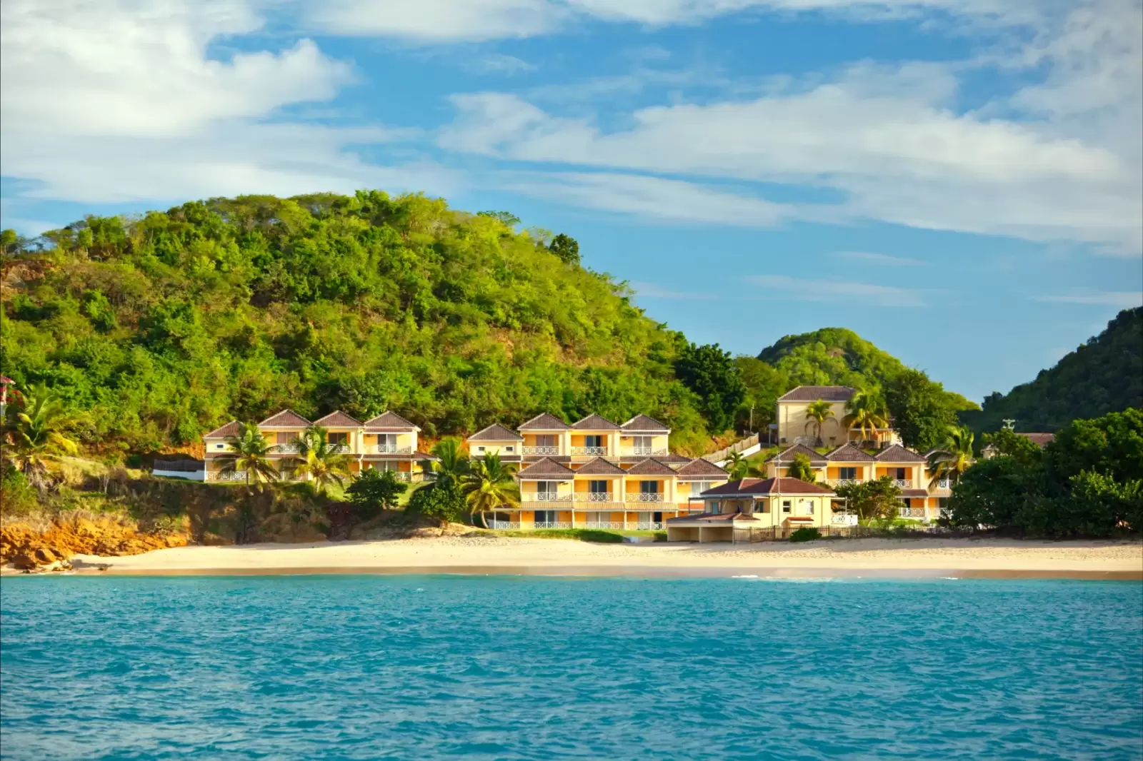 view to an antiguan beach and hotel from a boat view to an antiguan beach and hotel from a boat