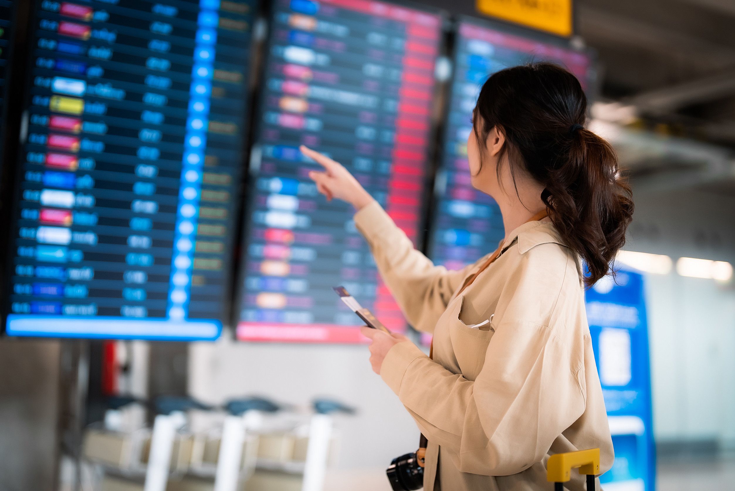 Young Asian Woman With Passport And Boarding Pass As A Hand In International Airport Looking